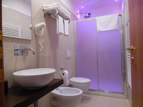 a bathroom with a toilet and a sink and a shower at Acquamarina B&B in Martinsicuro