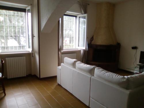 a living room with a white couch and two windows at Casa Lory in Marone
