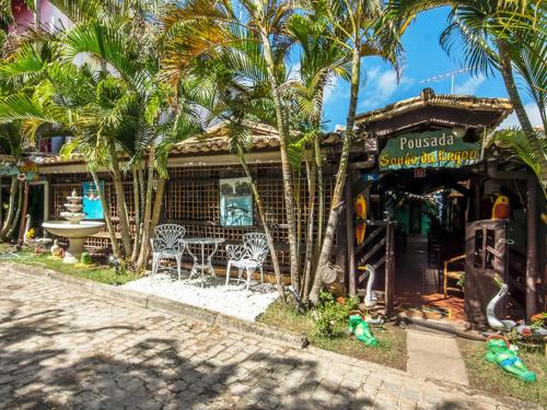 a restaurant with palm trees in front of a building at Pousada Sonho da Lagoa in Praia do Forte