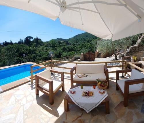 um pátio com cadeiras, um guarda-sol e uma piscina em La Casetta Nel Bosco em Fosco