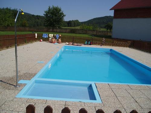 a large blue swimming pool in a yard at Restaurace a Penzion Česká Hospoda in Heřmanice