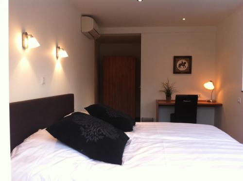 a bedroom with a white bed with two pillows on it at Hotel Restaurant de Sleutel in Riethoven
