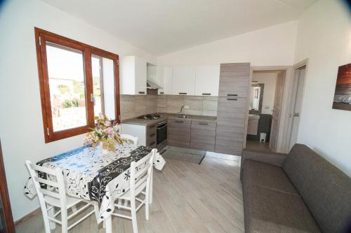 cocina y comedor con mesa y sofá en Sant'Anna Apartments, en Budoni