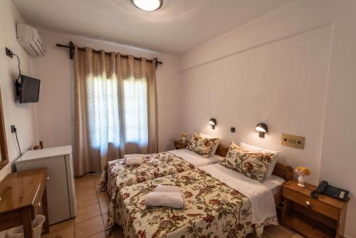 a small bedroom with a bed and a television at Hotel Sylvia in Kinira