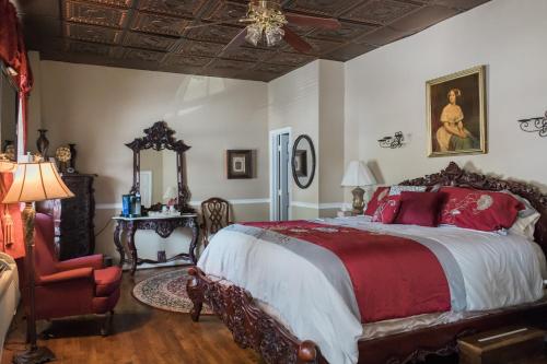 a bedroom with a large bed and a chair at Inn at the Olde Silk Mill in Fredericksburg