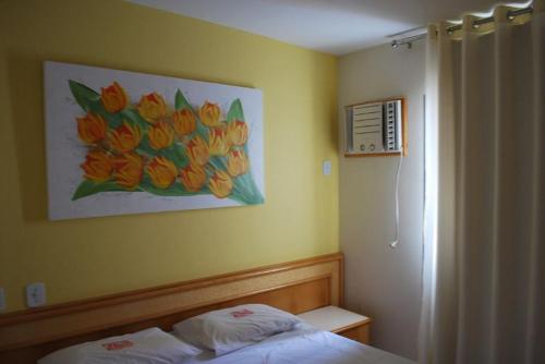 un dormitorio con una pintura de flores en la pared en Eldorado Thermas Park - Achei Ferias, en Caldas Novas