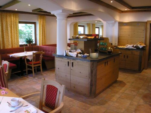 a restaurant with a counter and a table and chairs at Hotel-Garni Weidacherhof in Leutasch