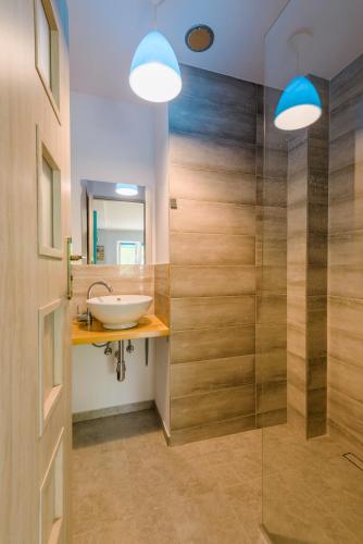 a bathroom with a sink and a glass shower at Verona, pobyt blisko natury in Kąty Rybackie