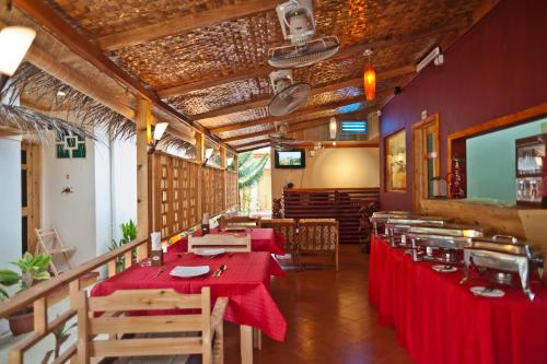 a dining room with red tables and chairs at Stingray Beach Inn in Maafushi