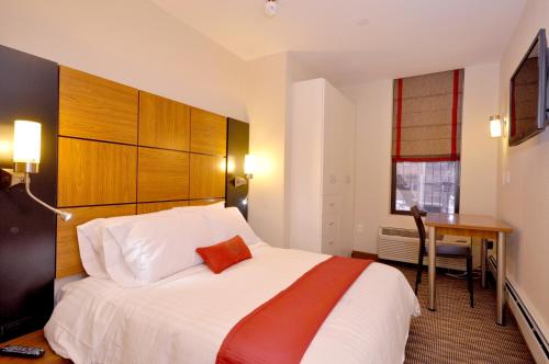 ニューヨークにあるホテル ファイブ44の大きなベッドとデスクが備わるホテルルームです。