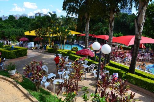 a resort with a pool and tables and chairs and people at Sol das Caldas - Achei Férias in Caldas Novas