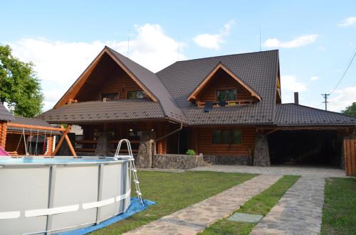 a house with a gambrel roof with a pool at Sadyba Pikuy in Bilasovytsya