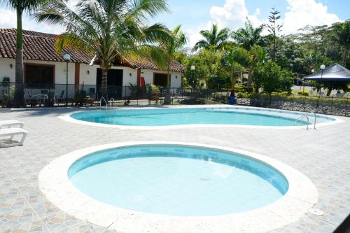 una gran piscina en un patio con una casa en Hotel Campestre la Loma curiti, en Curití