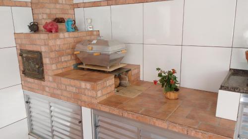 uma cozinha com um grelhador num balcão de tijolos em Pousada Sao Judas Tadeu em Guaratinguetá