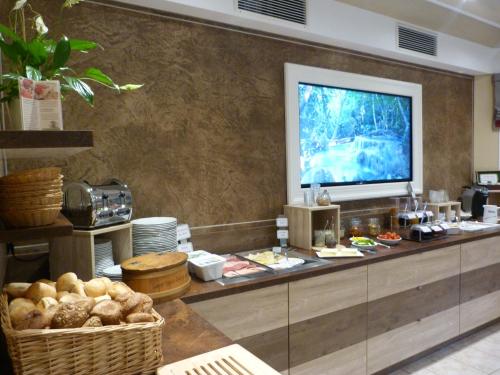 a buffet line with food and a tv on top at Flair-Waldhotel Mellestollen in Saalfeld