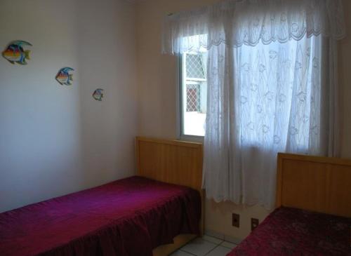 1 dormitorio con 2 camas y ventana en Aguas da Serra - Achei Ferias, en Caldas Novas