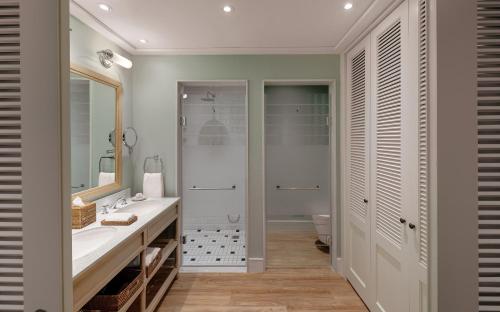 a bathroom with a shower, sink, and tub at Strand Hotel Swakopmund in Swakopmund