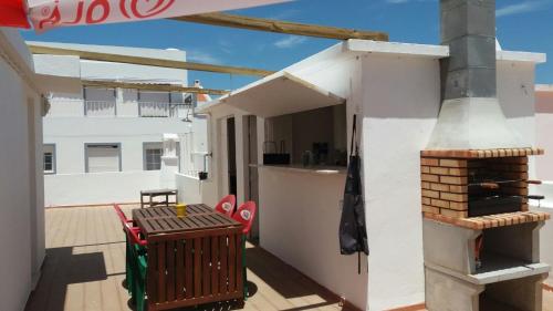 a balcony with a table and chairs on a roof at Casa da Madrinha I in Monte Gordo