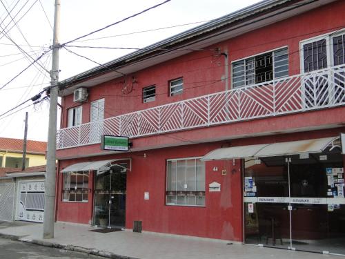 a red building on the corner of a street at Hotel Reimann in Indaiatuba