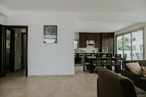a living room and kitchen with a large white wall at Villa Despoina in Paphos