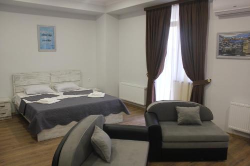 a bedroom with a bed and a chair and a couch at Apart Hotel Vera in Tbilisi City
