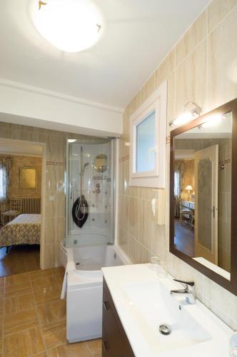 une salle de bain avec une baignoire, un lavabo et un miroir dans l'établissement Logis Hotel Restaurant Planes, à Saillagouse