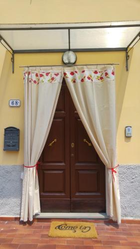 una puerta marrón con cortinas delante en La Casa dei Papaveri, en Lucca
