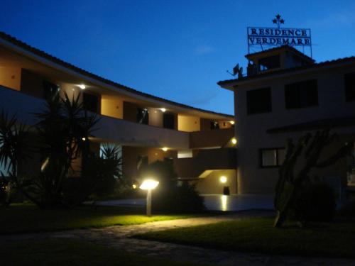 a building with a sign on top of it at night at Verdemare Sardegna Uno in Villasimius