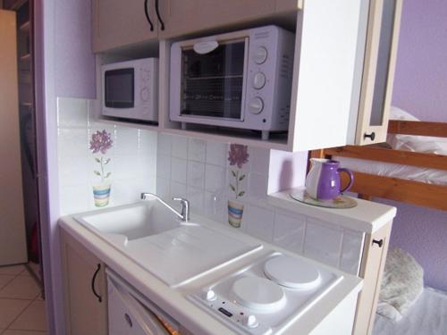 a kitchen with a sink and a microwave at vostok G173 in Le Corbier