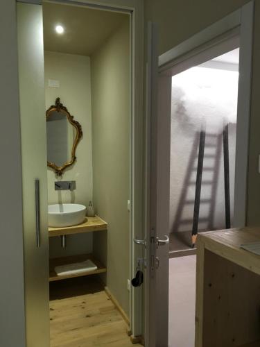 a bathroom with a sink and a mirror at Suite Romantica Fuga in Roncone