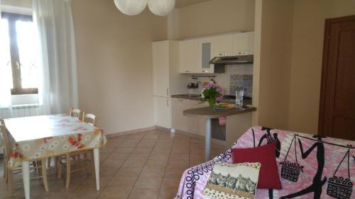 a living room with a table and a kitchen at La Casa dei Papaveri in Lucca