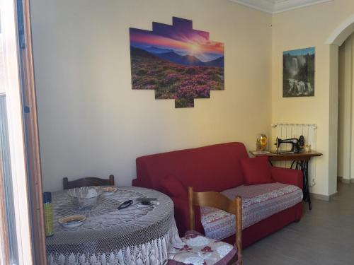 a living room with a red couch and a table at Datterina in Paceco