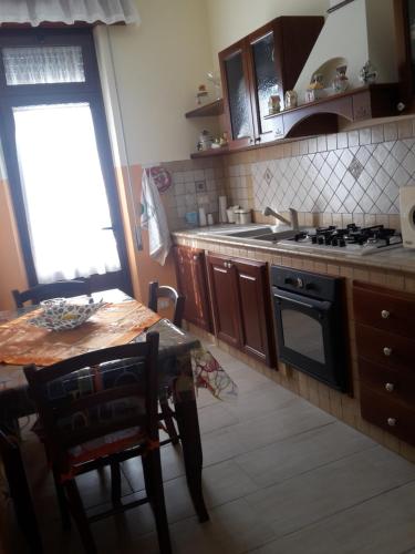 a kitchen with a table and a stove top oven at Datterina in Paceco