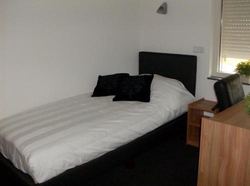 a bed with black pillows on it in a room at Hotel Restaurant de Sleutel in Riethoven