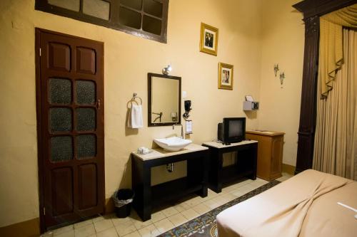 un baño con lavabo y espejo en El Gran Hotel, en Mérida