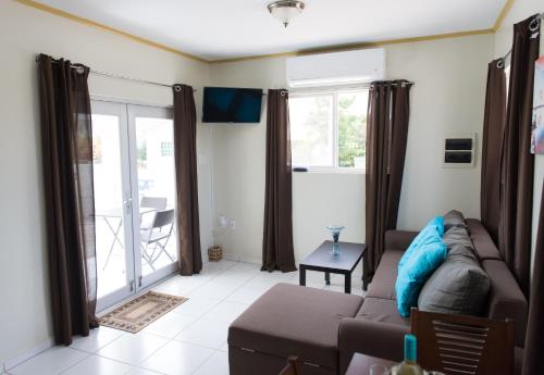a living room with a couch and a balcony at The Lush in Willemstad