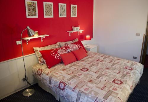 a red bedroom with a bed with red walls at Albergo al Sole in Val di Zoldo