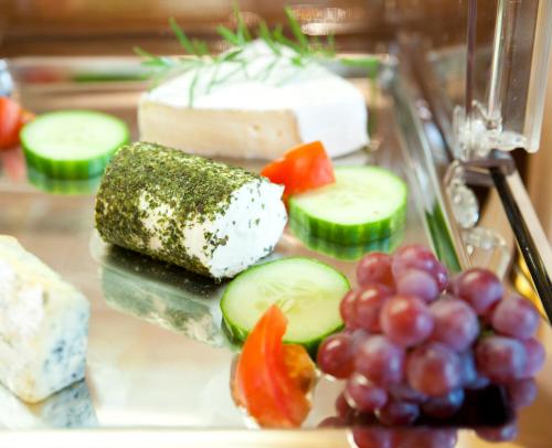 a plate of food with cheese and vegetables and grapes at Hotel Restaurant Osterbauer in Neunkirchen