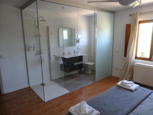 a bathroom with a glass shower and a sink at Camproig Holiday Home in Alaró