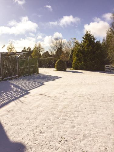 a tennis court with a fence and sand on it at Tongariro Crossing Lodge in National Park