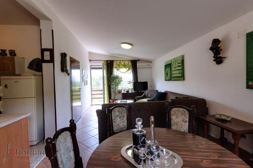 a kitchen and living room with a table and a couch at Rajski vrt in Crikvenica