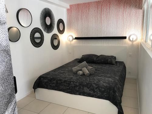 a bedroom with a bed and mirrors on the wall at Cap Locations Naturisme in Cap d'Agde