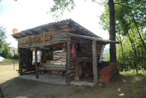 a small wooden shed with a bench in the grass at Etno selo Stanojevic in Boljevac