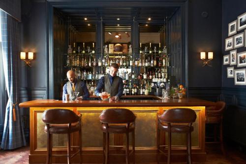 two men sitting at a bar in a pub at The Roseate Edinburgh - Small Luxury Hotels of the World in Edinburgh