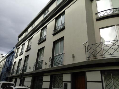 a white building with windows and balconies on a street at Hotel Elisa Cole in Santiago