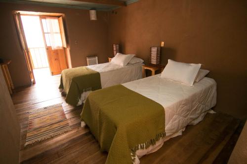 a bedroom with two beds and a window at Hotel Casona Distante in Alcoguaz