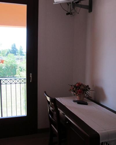 a table with a vase of flowers on it with a window at Ca Florian in Zero Branco