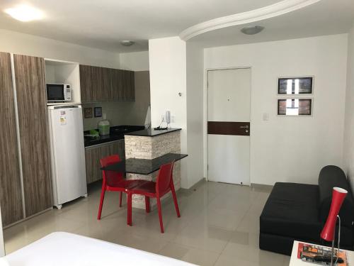 a kitchen and a living room with a table and chairs at Studio Everest Flats in Recife