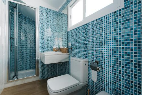 a blue tiled bathroom with a toilet and a sink at Hostly Acetres 2A-Penthouse in City Center-Fibre-Parking Opt in Seville
