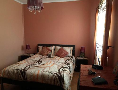 ein Schlafzimmer mit einem Bett, zwei Tischen und einem Fenster in der Unterkunft Dunes of Martil families only in Martil
